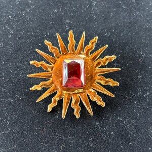 Radiant Gold Sunburst Brooch with Red Gem